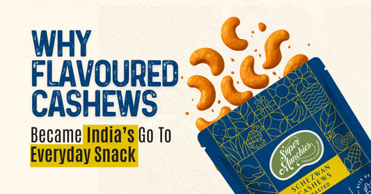 A blue snack packet labeled "Super Munchies Schezwan Cashews" with cashews spilling out, alongside bold text about flavoured cashews as a popular snack in India.