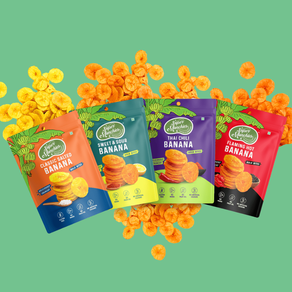 Four packages of banana chips with colorful packaging on a green background