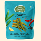 Super Munchies masala okra vacuum cooked chips packaging with okra, red chili, and lemon on blue background